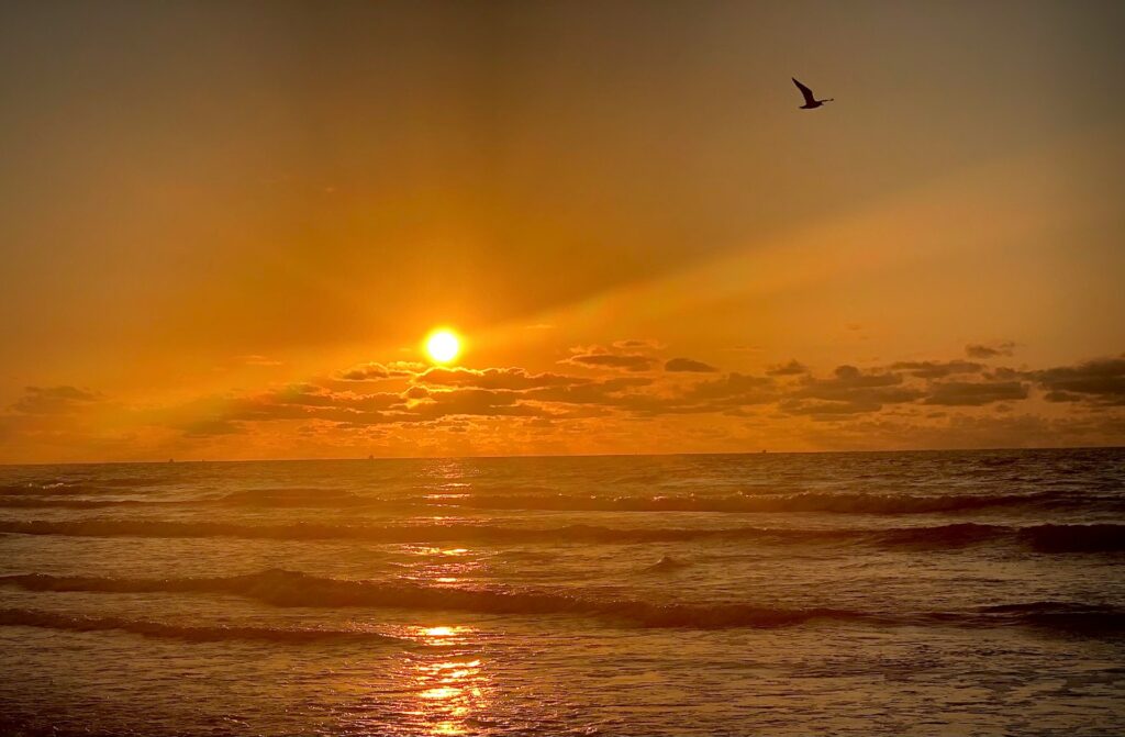Sunset over Galveston beach waters