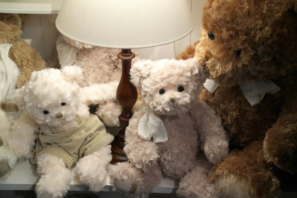 Stuffed Bears near a lit lamp with lamp shade