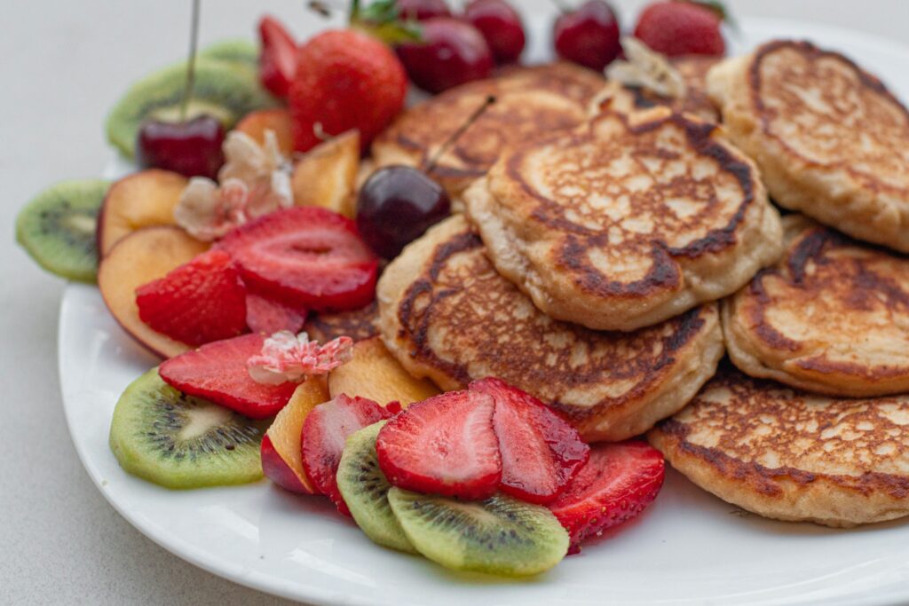 Pancake breakfast with strawberries, cherries, and kiwi