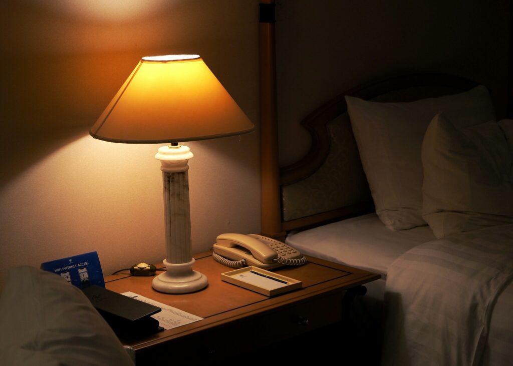 Hotel room with desk, lamp, phone, and note pad